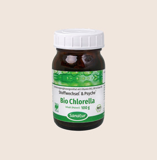Jar of Bio Chlorella with a white cap on a beige background