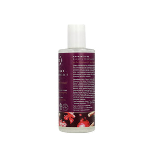 A bottle of hair and skin care product with a white cap and a dark purple label featuring German text and red pomegranate illustrations, shown on a plain white background.